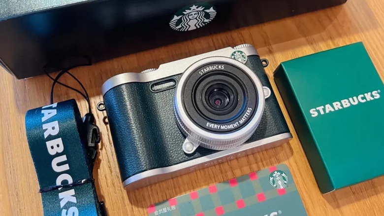 Green Starbucks branded camera with accessories on desk