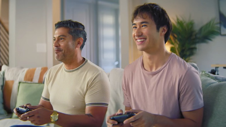 Two guys sitting on the couch playing a game with Steam Controllers