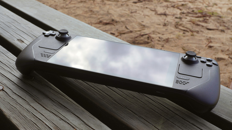 A Steam Deck placed on a wooden surface.
