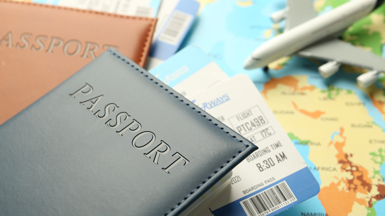 passport covers, tickets, and an airplane model on top of a map