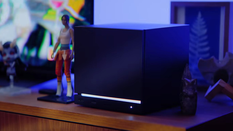The Steam Machine sitting on a desk next to an action figure of the protagonist from the Portal series
