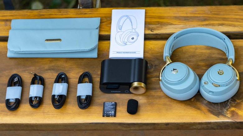 The SteelSeries Arctis Nova Elite and accessories on a wooden bench.
