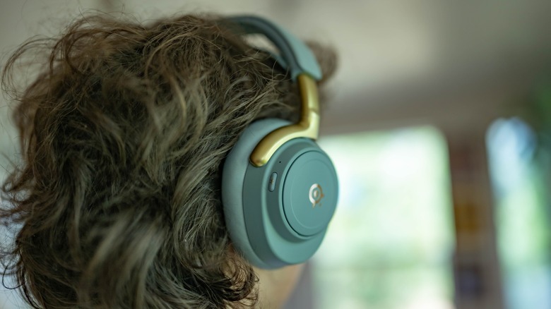The SteelSeries Arctis Nova Elite worn by a person facing away from the camera.