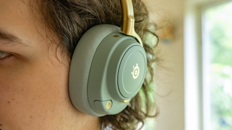 Close-up of the SteelSeries Arctis Nova Elite while they are being worn by a person.
