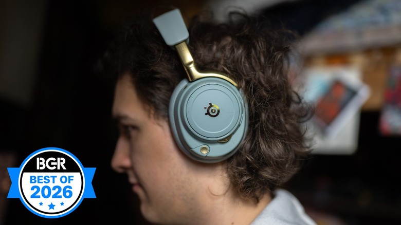 The SteelSeries Arctis Nova Elite worn by a young man in front of an out of focus room.