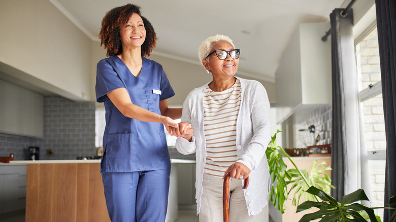 a nurse helps an elderly woman walk