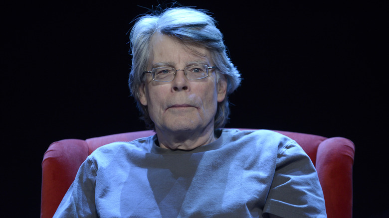 Stephen King sitting in a chair