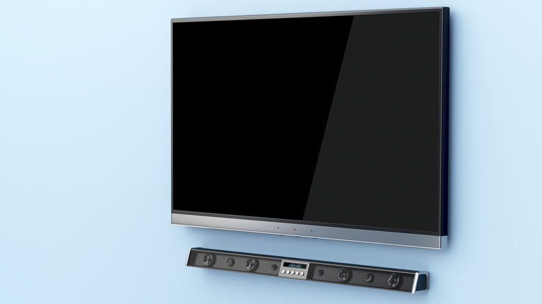 A soundbar installed below a wall-mounted TV.