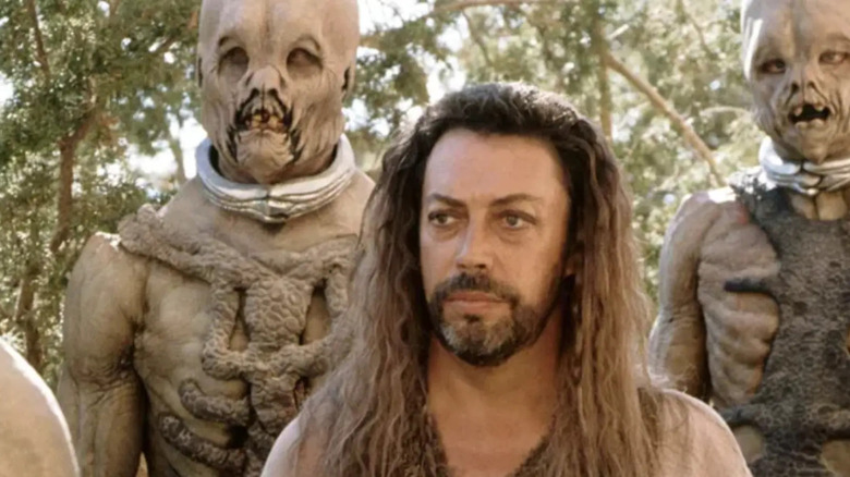 Gaol (Tim Curry) standing between two aliens on 