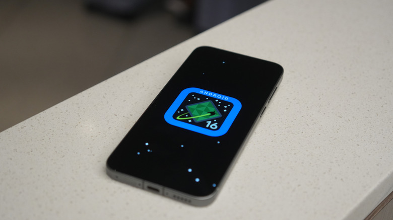A phone displaying the official Android 16 logo, inspired by space mission suit patches.