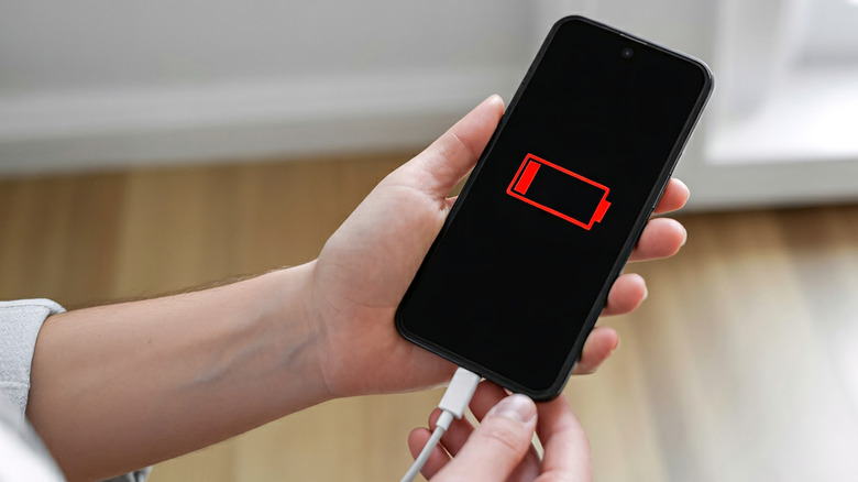 A person charging a phone that is completely drained