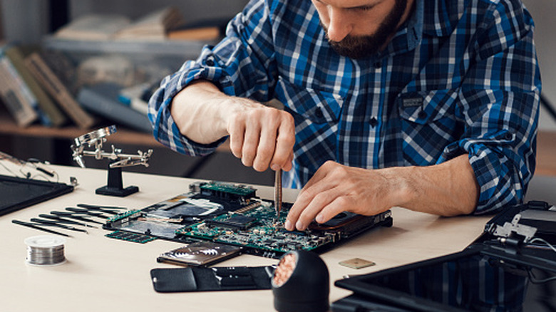 A person disassembling a laptop for at-home repair