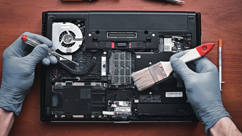 Technician dusting inside of laptop