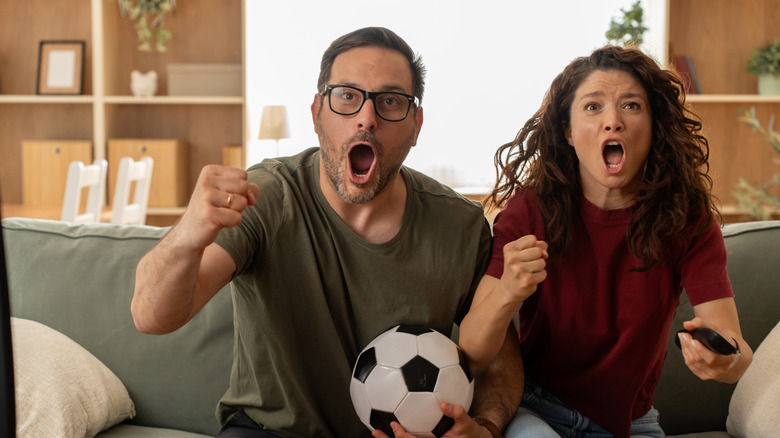 a couple watching soccer on TV