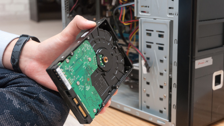 Person removing hard drive from a PC tower