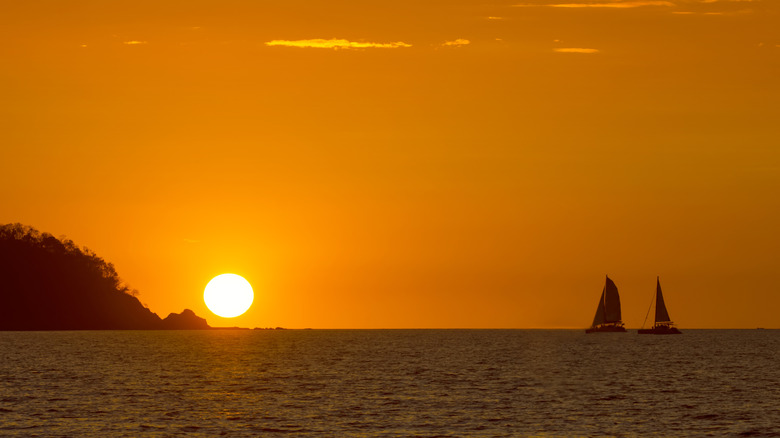 Sun over ocean with a glowing orange sky
