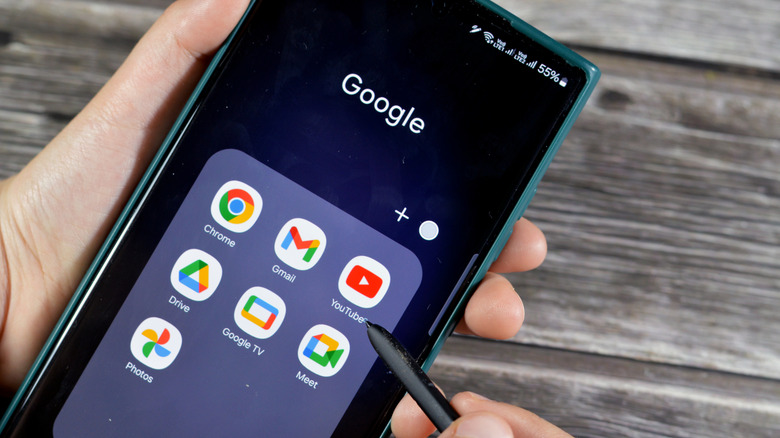 a list of Google apps on a Samsung phone while someone holds a stylus next to it