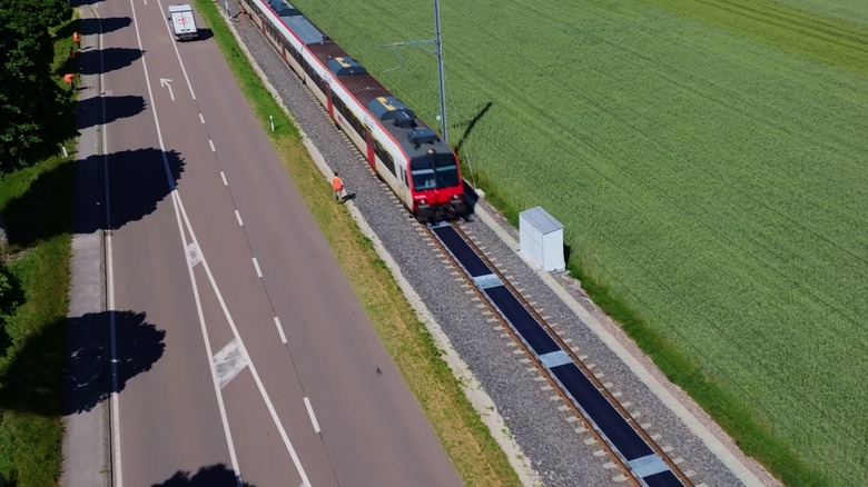A train passing over Sun-Ways solar panels placed between rails.
