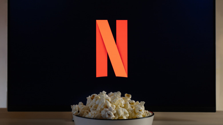The Netflix logo on TV, with a bowl of popcorn in the forefront.
