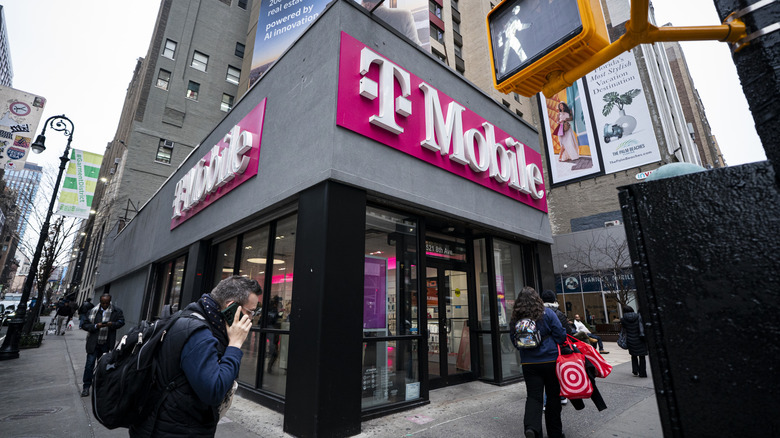 A T-Mobile logo on a storefront in an urban area.