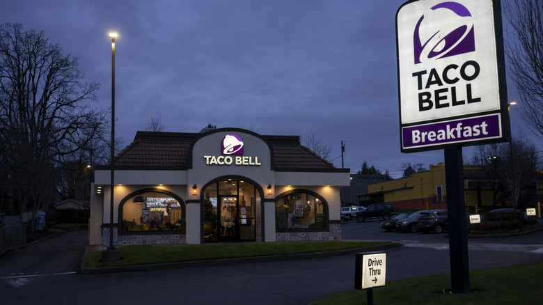 front view of a taco bell with a drive-thru sign near the road