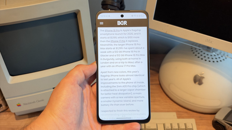 TCL P80 Ultra being held in one hand above a desk with Max Ink Mode switched on