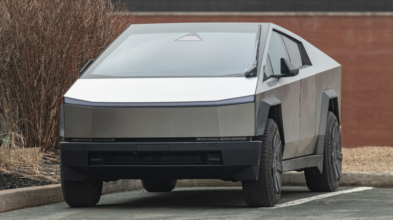 A silver Tesla Cybertruck sitting in a parking lot