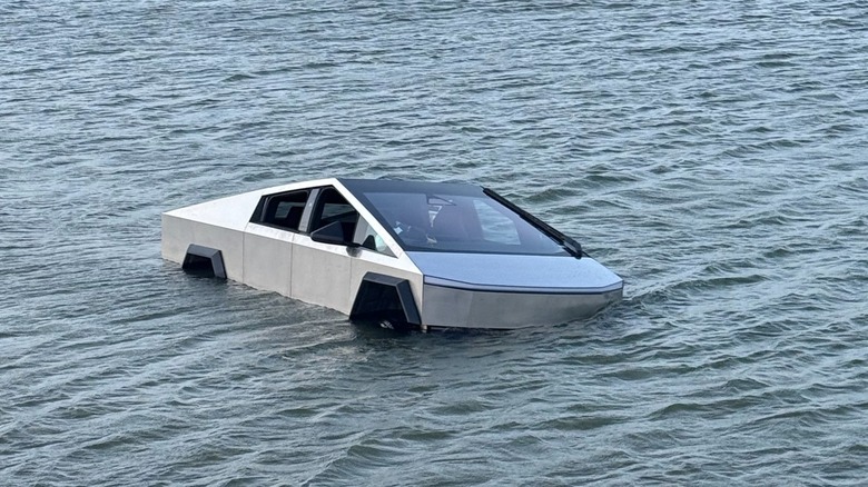 A silver Cybertruck is submerged in a body of water after being driven into it purposely