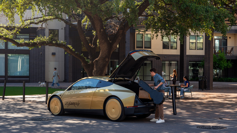A man loading luggage into the trunk of a Tesla Cybercab