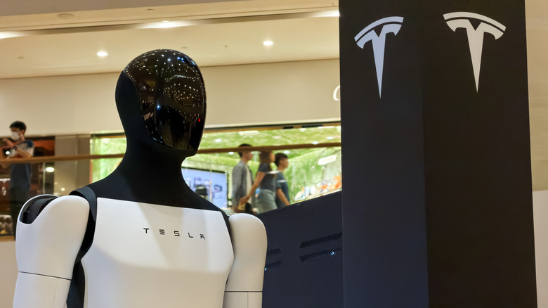 Optimus robot near a Tesla sign
