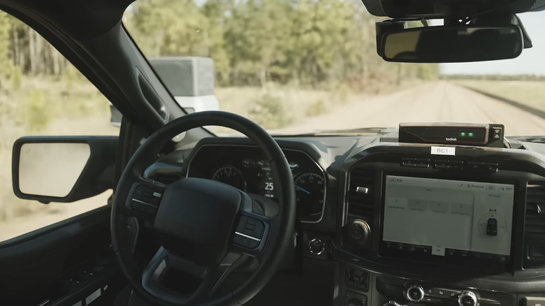 Inside the cab of an autonomous Kodiak AI truck as it drives along a road.