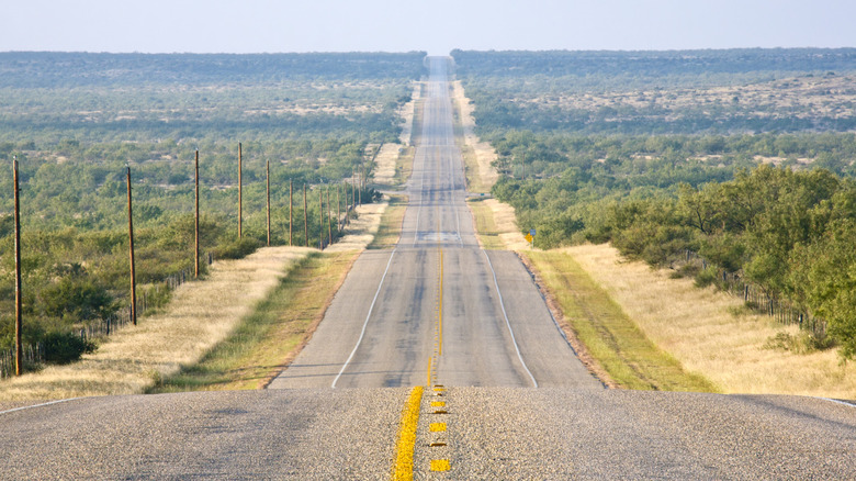 A long straight rural highway heads off into the distance in Texas.