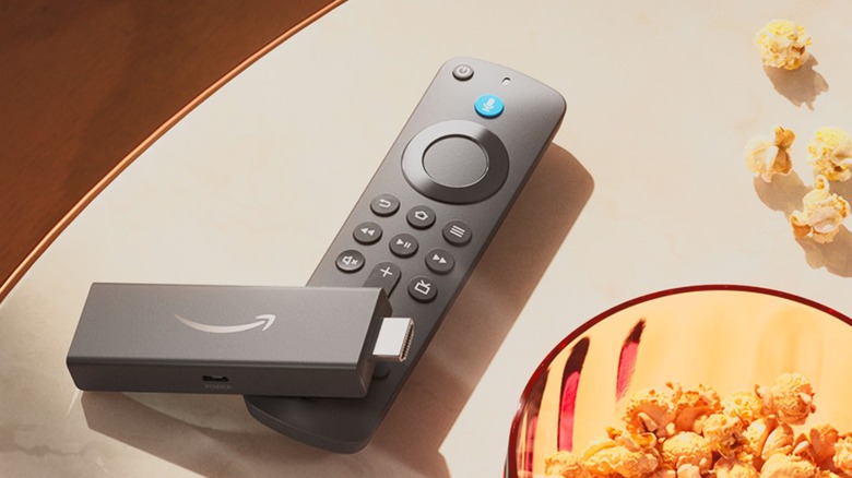 Amazon Fire TV Stick and remote on table next to bowl of popcorn