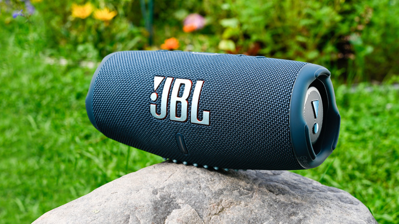 JBL Charge 5 Portable speaker on a rock outdoors