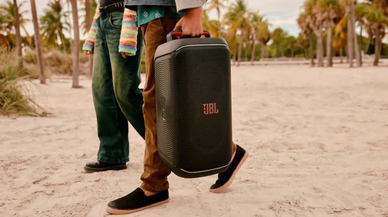 Man carrying a JBL party box 120 with speaker lights off