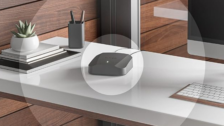 A single Wyze Mesh Router device with the small green light on at the center