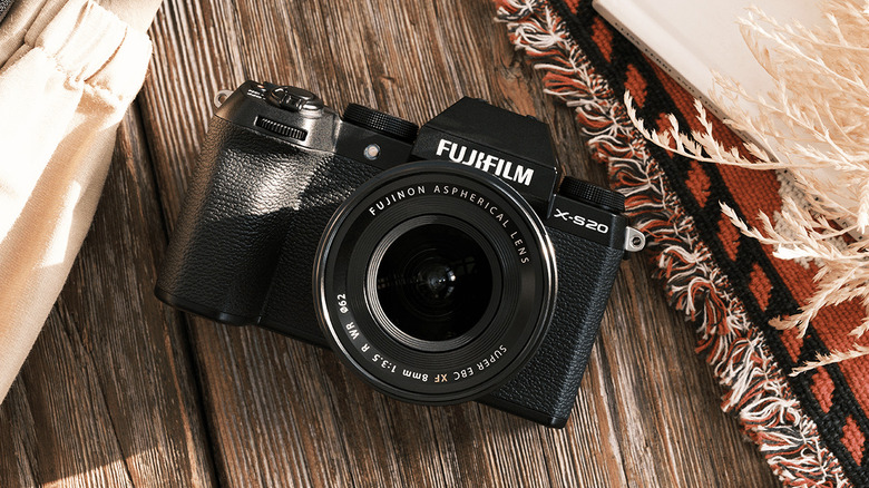 A Fujifilm X-S20 camera on a wooden surface