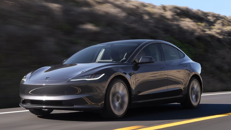 Tesla Model 3 electric vehicle sedan driving on a mountain road