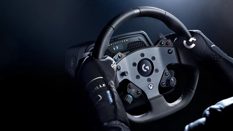 A person wearing racing gloves holding the Logitech G Pro Racing Wheel