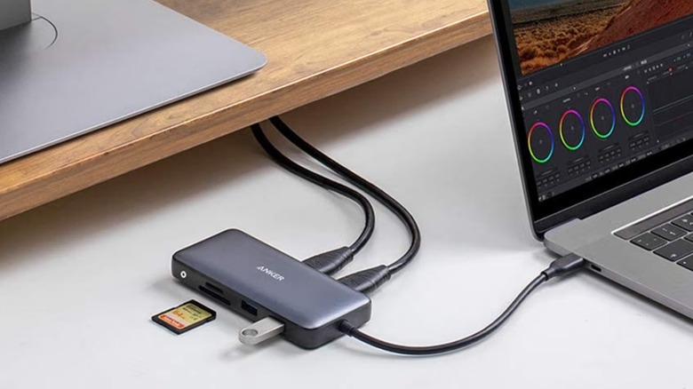 Cables and a flash drive plugged into the Anker A8380 8-in-1 USB-C hub, which is connected to a laptop.