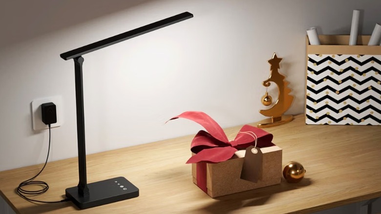 The Lepro LED desk lamp on a table, illuminating the wooden surface.