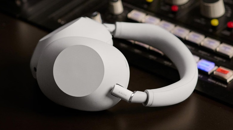 The Sony WH-1000XM6 noise-canceling headphones on a desk beside a sound mixer.