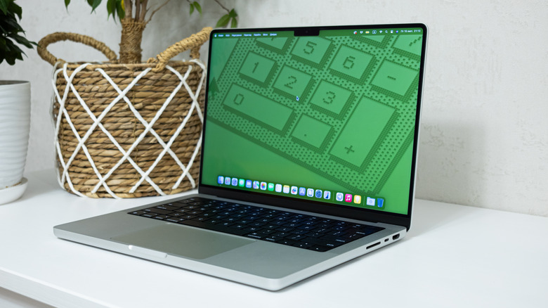 The Apple MacBook Pro M4 on a desk, with a green image on the screen.