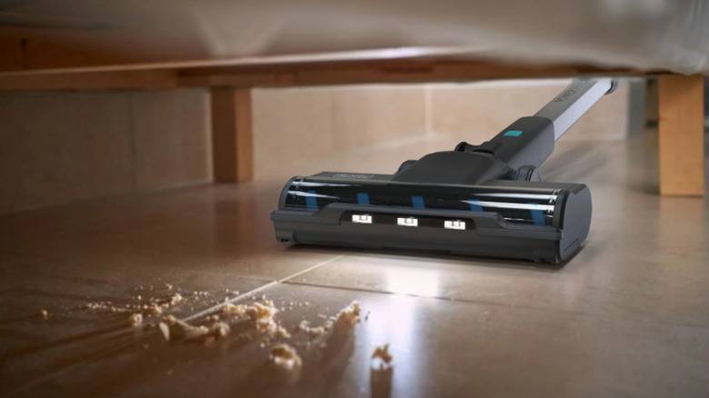 The Black+Decker Powerseries+ BDSV2 corded stick vacuum under a piece of furniture