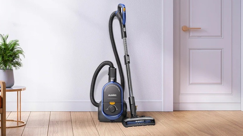 The Eureka WhirlWind XL NEN186BL canister vacuum on standby near a wall.