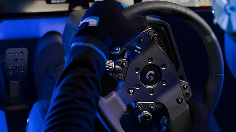 A person turning the Logitech G Pro Racing Wheel, bathed in blue light