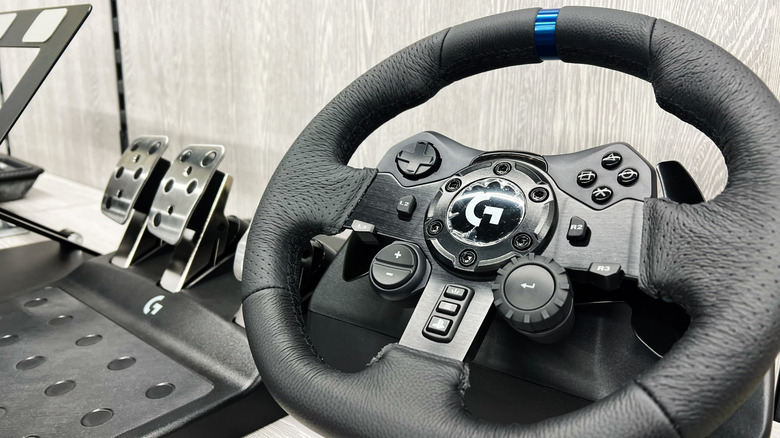 The Logitech G923 steering wheel next to its pedals