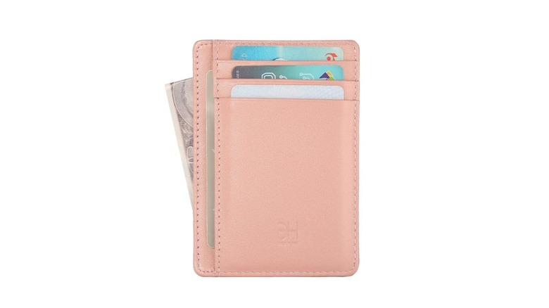 A minimalistic light pink women's wallet with some cards and money inside it
