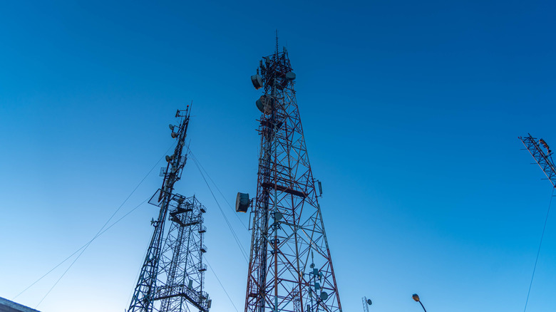Two cell site towers against a backdrop of blue sky