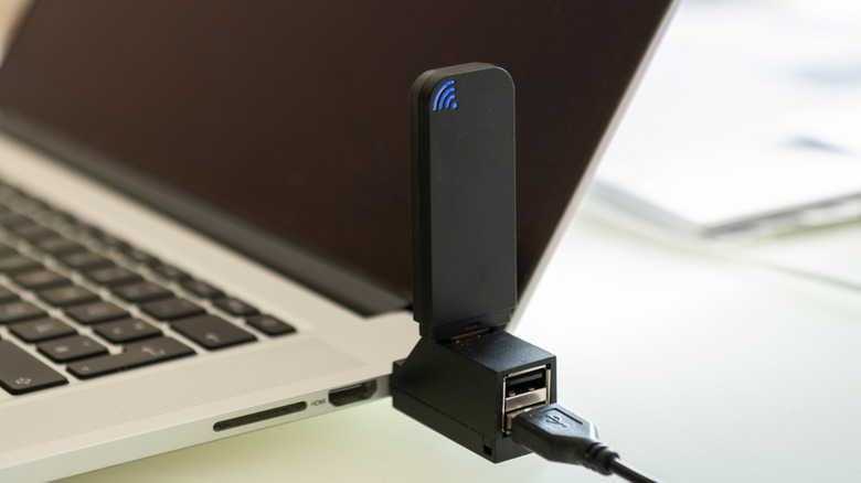 wi-fi USB dongle plugged into the side of a laptop